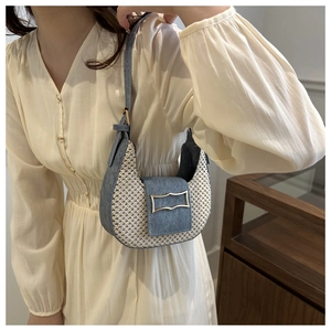 Détail du sac croissant tissé avec bordure en jean et fermoir doré vintage