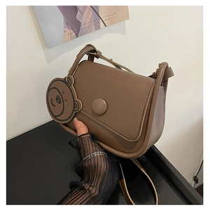 Détails du sac besace vintage marron avec boucle ronde et charmant pendentif ours