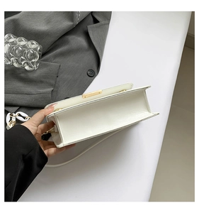 Top view detail of a white leather shoulder bag showing the spacious inner compartment