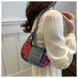 Détail du sac croissant coloré avec bandoulière en denim bleu et boucle en métal doré