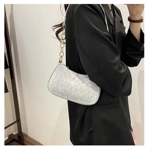 Close-up of light gray quilted wool underarm bag with gold chain strap detail