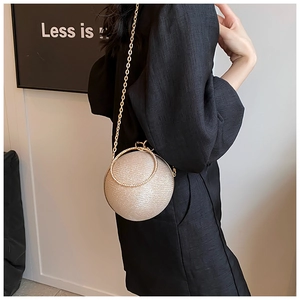 Detail of champagne gold sphere bag with glitter texture and round metal handle