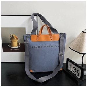 Detail of grey canvas tote bag with Light Fashion print and leather reinforcement