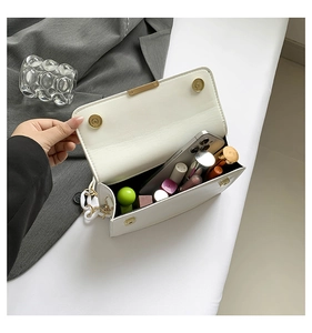 Detail view of white leather crossbody bag interior showing spacious room for phone and lipstick