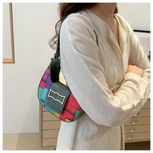 Détail du sac selle patchwork coloré avec fermoir doré sur rabat en daim élégant