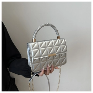 Detail of silver quilted handbag showing geometric stitching and gold chain strap