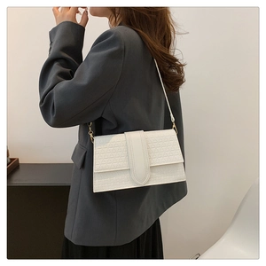 Close-up of white plaid crossbody bag with textured geometric pattern and gold hardware