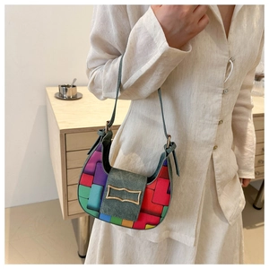 Detail of colorful patchwork hobo bag with green denim flap and gold buckle