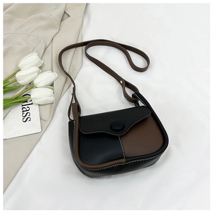 Detail of two-tone PU leather crossbody bag with stitching and matte black buckle