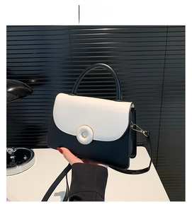 Détail du sac bicolore avec rabat en cuir blanc et fermoir en métal doré