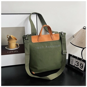 Detail of olive green canvas tote with brown leather handles and adjustable shoulder strap