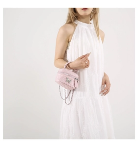 Detailed view of pink quilted handbag with silver butterfly clasp and chain strap
