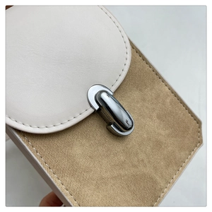 Detail of silver twist lock on beige canvas and khaki leather crossbody bag