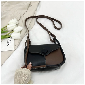 Detailed close-up of contrast color crossbody bag with white stitching and large buckle