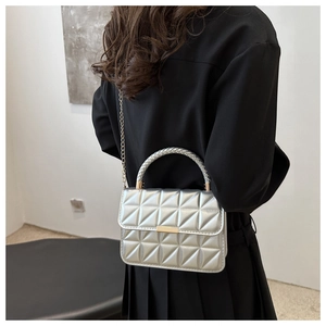 Silver quilted crossbody bag detail with metallic finish and gold chain strap