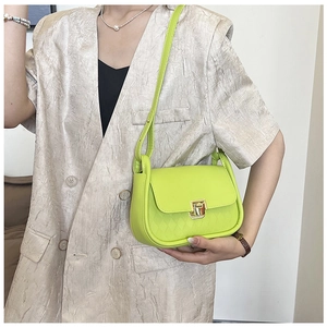 Detail of neon green crossbody bag with diamond lattice texture and gold metal buckle