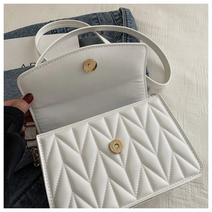 Detail der weißen Stepptasche mit V-Nähten und goldenem Magnetverschluss für Damen