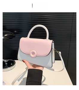 Vue détaillée du sac bandoulière bicolore rose et blanc avec boucle dorée ronde