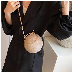 Detail of a spherical gold evening bag with sparkling glitter and rhinestone handle
