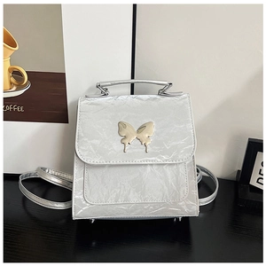 Close-up of metallic silver bag with textured finish and golden butterfly buckle