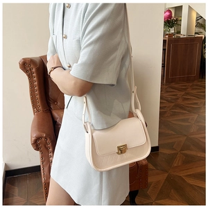 Detail of cream white crossbody bag with diamond lattice pattern and gold twist lock