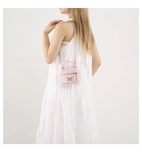 Detail of pink quilted mini box bag with silver butterfly clasp and chain strap