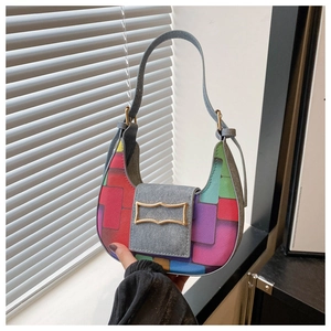 Close-up of geometric patchwork crescent bag with multi-color panels and metal buckle