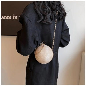 Detail of champagne gold spherical bag featuring sequin texture and metallic ring handle