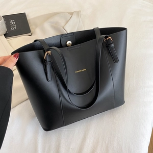 Minimalist black PU tote bag with gold lettering shown from a top-down interior view