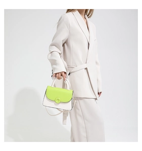 Detail of neon green and white color-block crossbody bag with cylindrical top handle