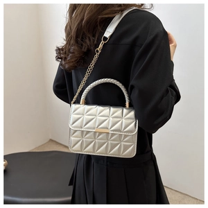 Detail of silver geometric quilted handbag with metallic finish and gold chain strap