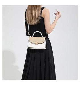 Vue détaillée du sac bandoulière crème et beige avec fermoir doré sur un mannequin