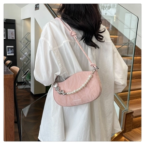 Detail of pink pleated bag featuring pearl and silver heart chain with delicate rope strap