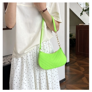 Neon green crescent bag with chevron texture and gold chain strap on shoulder
