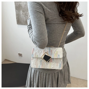 Detail of white leather shoulder bag with rainbow bead embroidery and chain strap