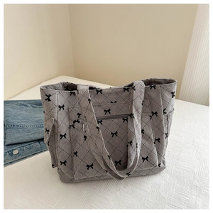 Macro view of grey corduroy tote bag with black bow lattice pattern and side pockets