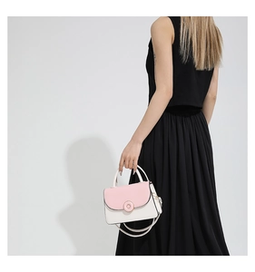 Detail view of pink and white patchwork crossbody bag with metal ring buckle on black dress