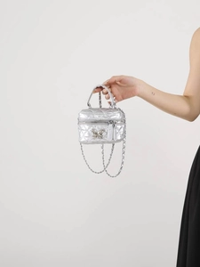 Silver quilted mini box bag with metallic finish and elegant bow detail