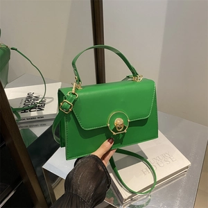 Chic emerald green box-shaped leather handbag with gold buckle and handle