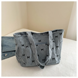 Detail of light blue corduroy tote bag featuring bow pattern and diamond stitching