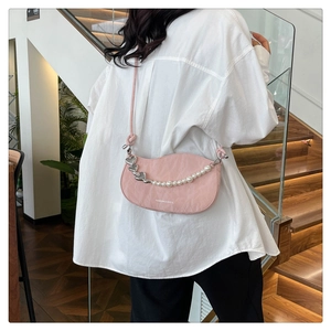Detail of pink crescent bag with pearl heart chain and Fashion & Bags text on the side