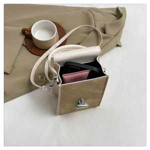 Detailed interior of a cream and khaki leather phone bag with a secure silver twist lock