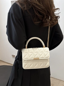 Chic cream quilted crossbody bag with woven handle and gold chain strap shown on model
