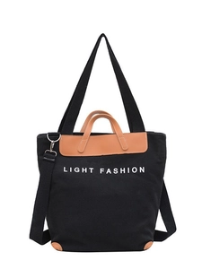 Black canvas tote bag with brown leather trim and Light Fashion text on white background
