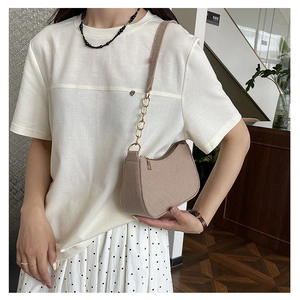 Detail of light beige quilted shoulder bag with gold chain strap and elegant stitching
