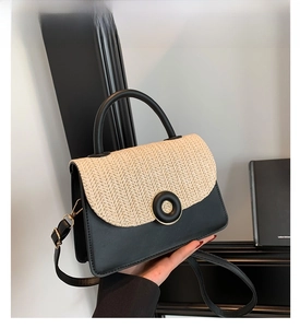 Close-up of contrast stitching straw flap and circular gold-tone hardware on black bag