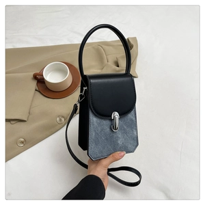 Detail of contrast mini handbag with black leather flap and silver metal lock closure