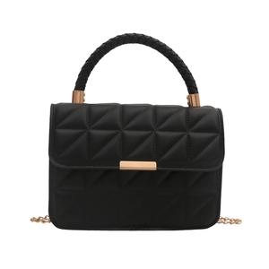 Quilted black leather handbag with woven handle and gold chain strap on white background