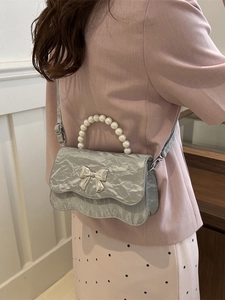 Silver textured pearl handle bag with butterfly ornament shown in lifestyle setting