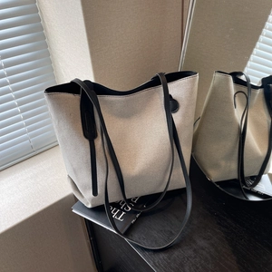 Large minimalist canvas tote bag with black leather trim and handles for daily commute